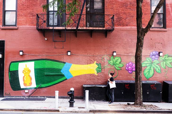 a mural of a champagne bottle on a brick wall